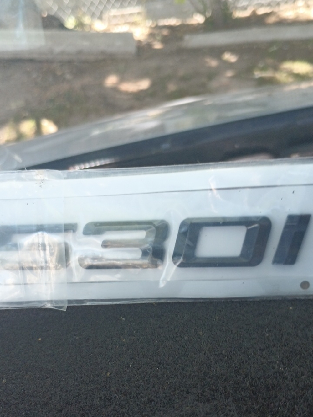 Glossy Black '530i' Automotive Emblem on White Backing